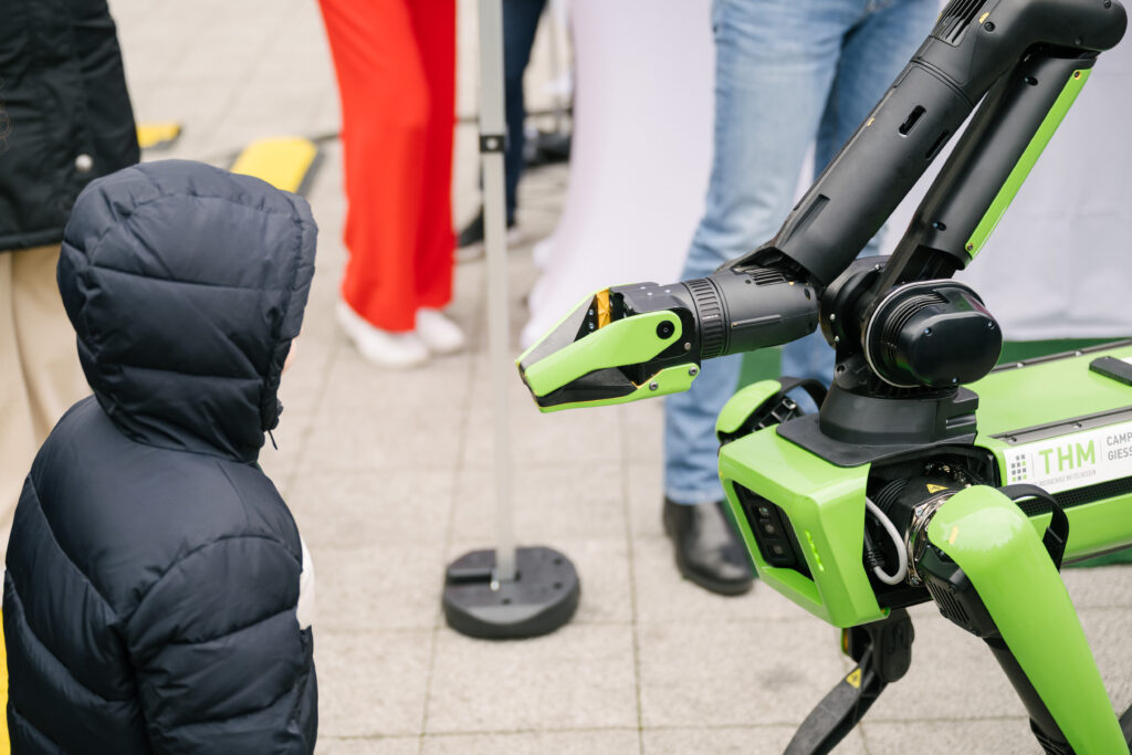 Kind mit Roboter bei der KI-Tour des Hessischen Digitalministeriums